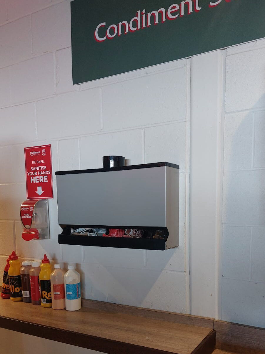 Sauce Station Condiment dispenser at Liverpool F.C's famous Anfield Stadium This condiment dispenser version designed specially for the Anfield Stadium combines an extra large gravity fed condiment sachet dispenser section with the standard tray top for sauce bottles or for use as a cutlery tray, in the middle of the tray is the Straws holder or alternatively it can be used as a pocket for Stirrers.